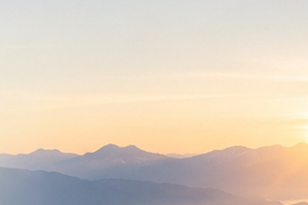 Soft morning light over layered mountain ridges.