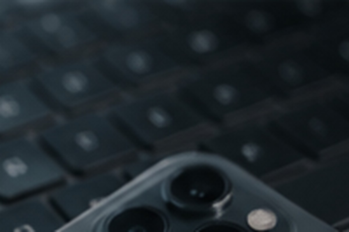 A close view of a smartphone camera resting on a keyboard.