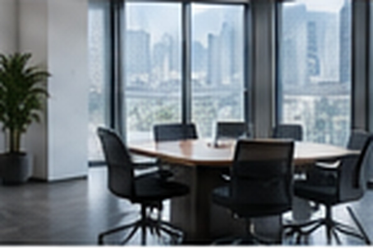 A bright meeting room with a large table and city windows.